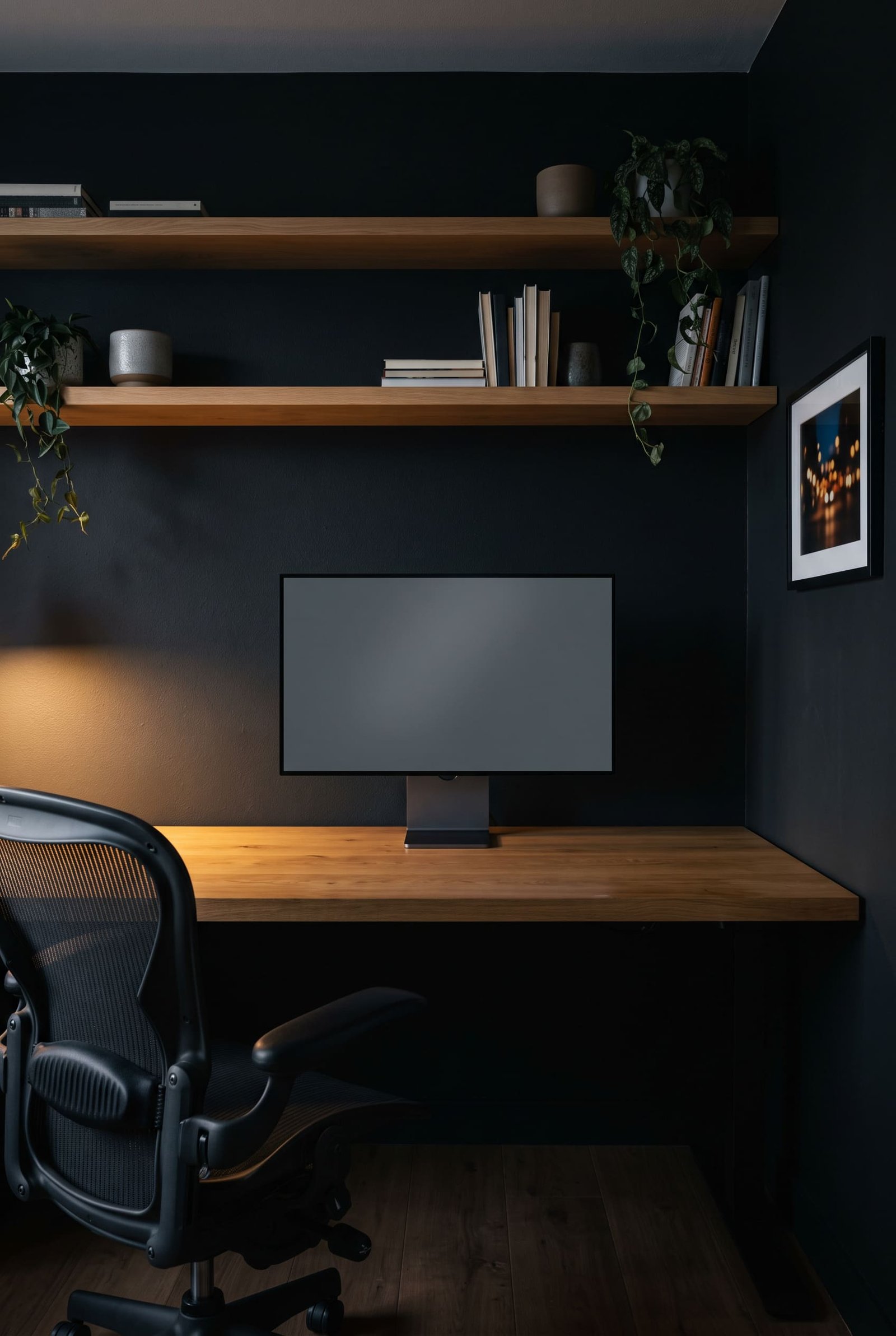 Dunkler Arbeitsplatz, Monitor mit leerem Bildschirm auf einem Holzschreibtisch, warmes Licht